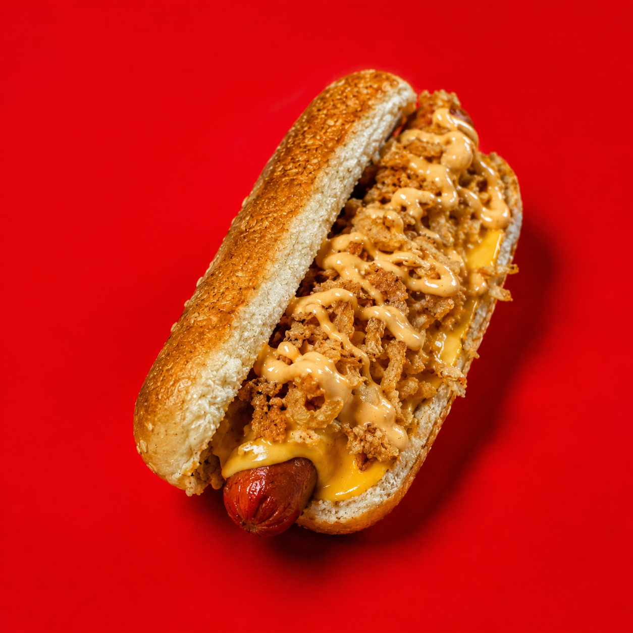 Cheese dog topped with crispy fried onions and drizzled house sauce