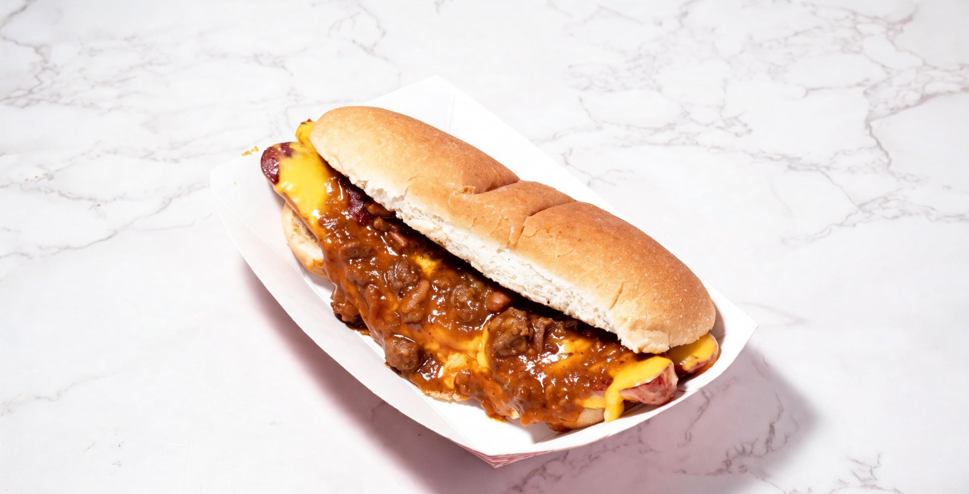 Hot dog smothered in beef chili and cheese sauce