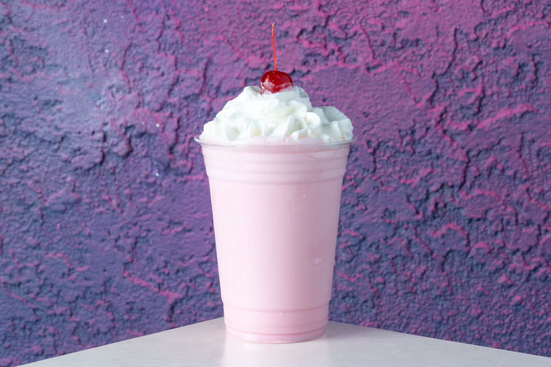 Space Dogs strawberry milkshake topped with whipped cream and a cherry